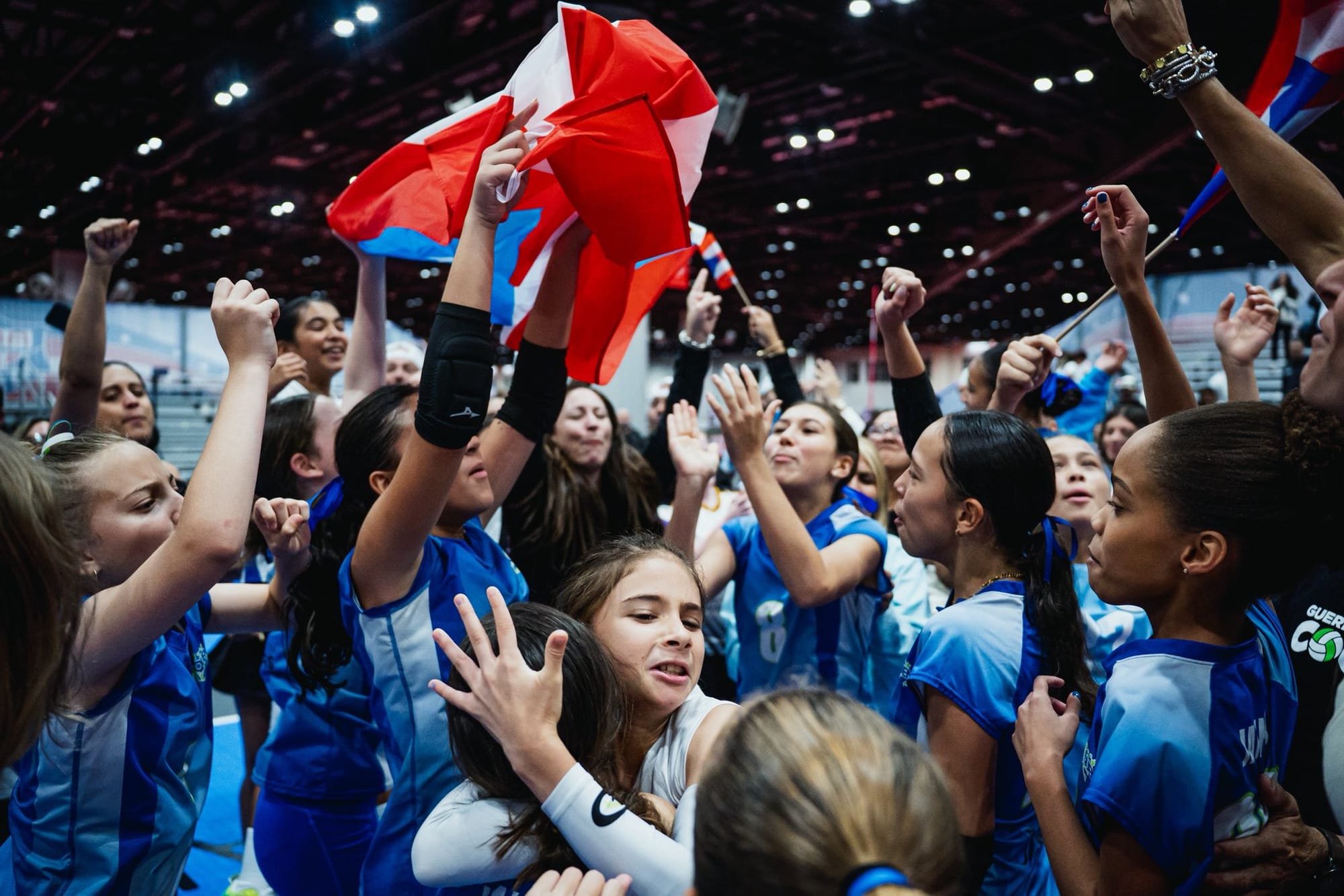 Jóvenes celebrando con la bandera de Puerto Rico en un campeonato deportivo